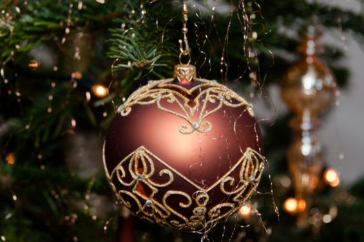 Decorative christmas ball hanging on pine - tree branch