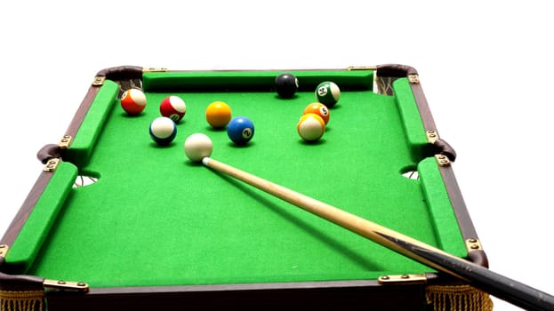 Miniature billiards table with cue and balls on white background