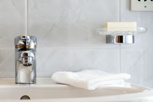 Bathroom faucet with washcloth and soap in soap dish.