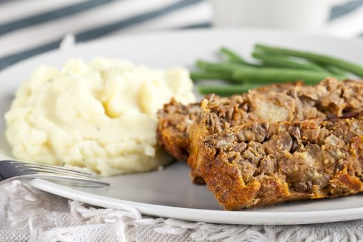 Vegetarian meal with lentil loaf, mashed potatoes and green beans.