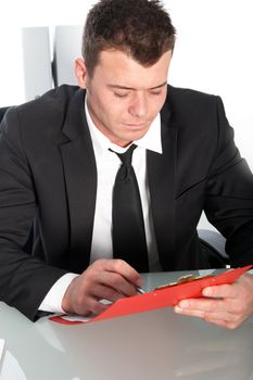 Professional young man studying a file at his desk
