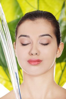 Portrait of beautiful clean face of woman under the stream of water