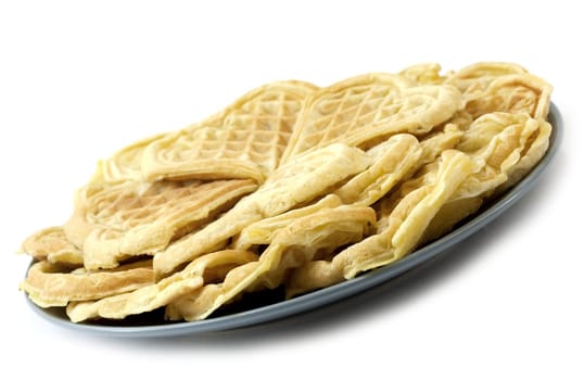 Pile of homemade golden waffles on a plate, on white