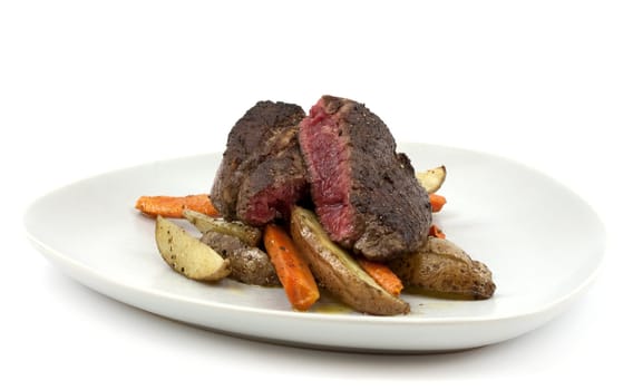 Fried bloody steak with potatoes and carrots isolated on white