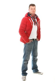 Handsome casual young man in trendy winter clothing standing with his hands in his pockets looking at the camera isolated on white