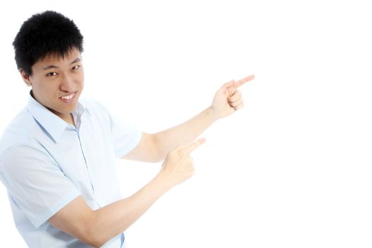 Casual young Asian man in shirtsleeves pointing with both hands towards blank white copyspace on the right of the frame isolated on white