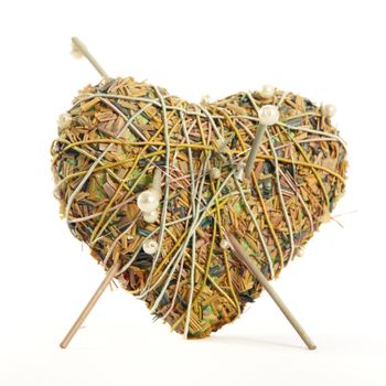 Heart shaped potpourri with aromatic dried flowers and herbs bound in thin twigs to give a romantic rustic heart isolated on white