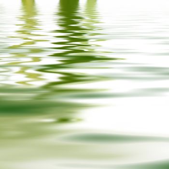 Reflection of greenery mirrored on the surface of calm rippled water for a background of tranquillity and wellbeing