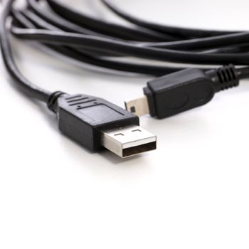 Colied computer USB cable for connecting peripherals on a white studio background