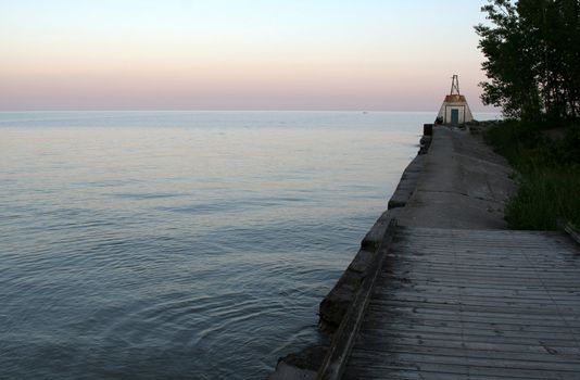 An old dock and lighthouse shot at evening.