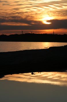 A sunset at Port Burwell featuring a reflection in a large puddle.
