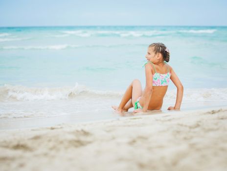 Adorable happy smiling little girl on beach vacation