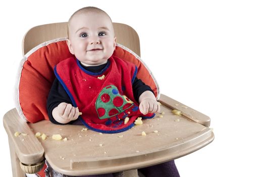 toddler eating potatoes in highchair