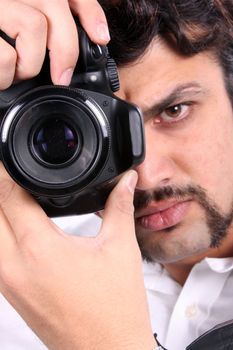 A closeup video of an Indian photographer with focus on the camera.