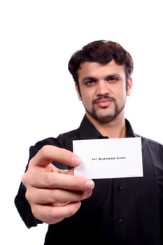 A young Indian guy showing his new business card, focus on the hand and card. Card left blank for designers editing.