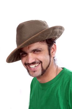A portrait of a handsome young Indian man wearing a hat, on white studio background.
