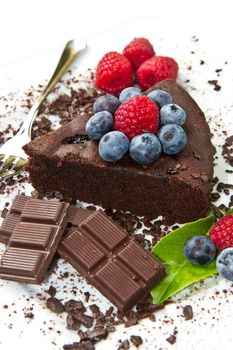 Piece of chocolate cake with fresh berry on white background 