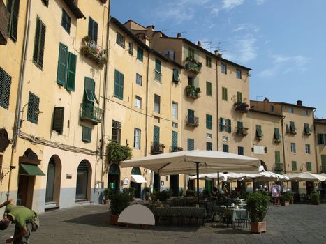 View from piazza Anfiteatro, former a Roman Ampitheatre, in Lucca. Tuscany, Italy. This square was built on the fundations of a Roman amphiteater built in the second half of the first century a. D. Later it became a quarry to supply the town with materials for churches and palaces. Several buldings were constructed inside this oval area in the Middle Ages