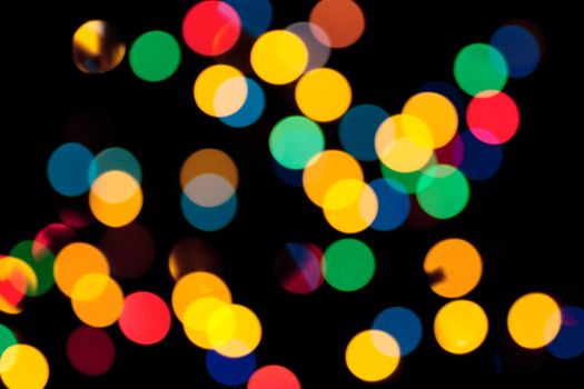 Abstract background with colorful defocused lights over black background