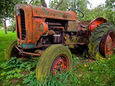 Old rusty red vintage tractor in a farm digital art manipulated