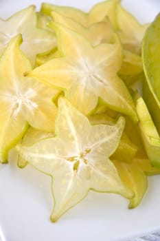 close up fresh starfruit sliced on white plate
