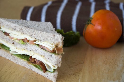 close up gaba bread sandwich with fresh tomato on wooden table