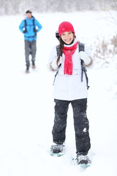 snowshoeing winter hiking. Active couple on snowshoes outdoors in snow walking in natural park in Canada, Quebec.