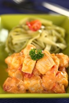 Fish goulash out of diamond dogfish prepared in Hungarian style served with pasta (Selective Focus, Focus on the front of the parsley and the two fish pieces on top) 