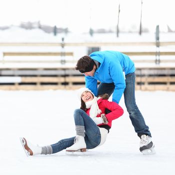 Ice skating couple having winter fun on ice skates in Old Port, Montreal, Quebec, Canada.