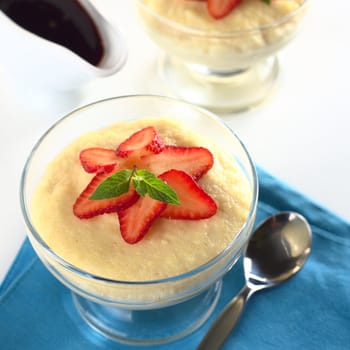 Semolina pudding with strawberry slices and mint (Selective Focus, Focus on the mint leaf)