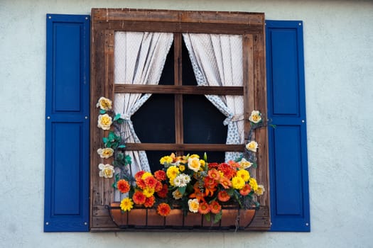 Country style window with flowers,planter, shutters and curtains