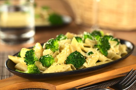 Baked broccoli and pasta with melted cheese and ground pepper on top (Selective Focus, Focus one third into the image) 
