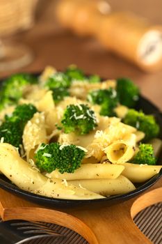 Broccoli and pasta baked with grated cheese and ground black pepper (Selective Focus, Focus on the broccoli floret in the front) 