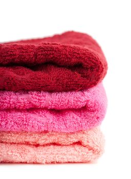 Stack of bright colorful towels over white background