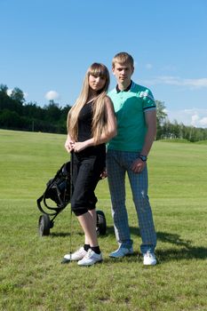 Beautiful couple staying on green golf field