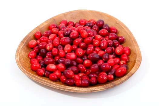 fresh red berries in wooden bowl, isolated on a white background