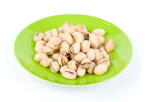 pistachios in a green plate, isolated on white background