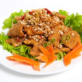 battered beef with peanut on a plate isolated on white