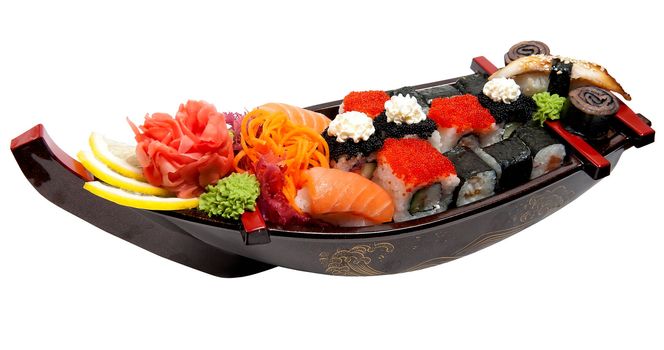 Set of sushi on wooden stand in the form of the boat isolated on white