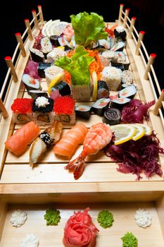 Set of sushi on wooden stand in the form of the bridge isolated on white