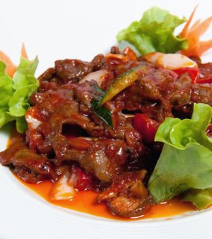 Roasted beef with vegetables on a plate isolated on white