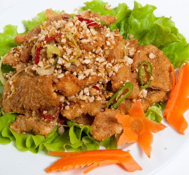 battered beef with peanut on a plate isolated on white