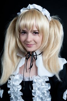 Portrait of young girl in anime lolita suit on black background