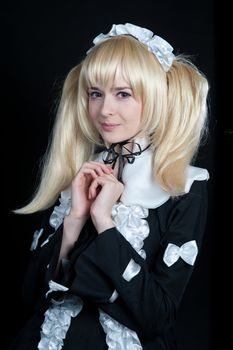 Portrait of young girl in anime lolita suit on black background