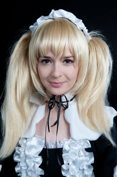 Portrait of young girl in anime lolita suit on black background