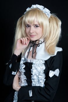 Portrait of young girl in anime lolita suit on black background