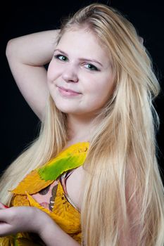 portrait girl in dress decorated with autumn leaves on black background