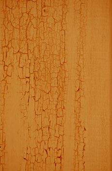 Yellow flaky paint on a wood background.