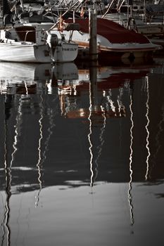 Boats and reflections of yachts in still water