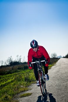 Man on road bike riding down open country road.